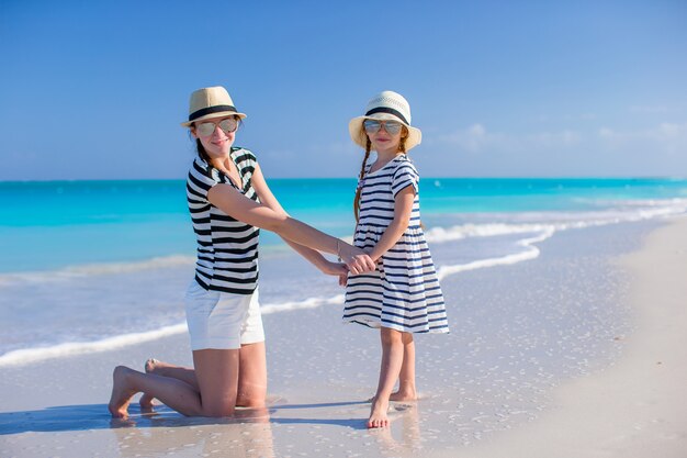 Bonne maman et petite fille à la plage blanche des Caraïbes