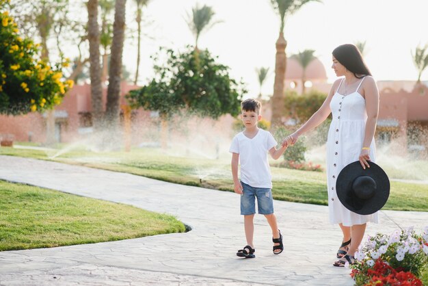 Bonne mère et fils aimants. Promenade en famille près des palmiers. Hôtel de plage en Turquie. L'heure d'été ensemble, la lumière du soleil. Bonne fête des mères.