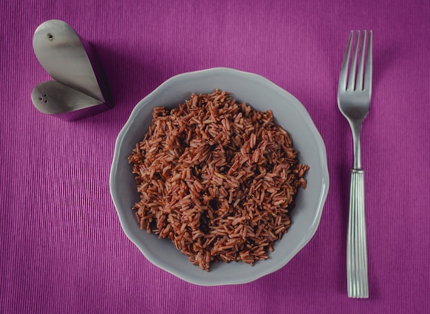 Une bonne nutrition diététique. Une assiette de riz brun sur une belle table violette