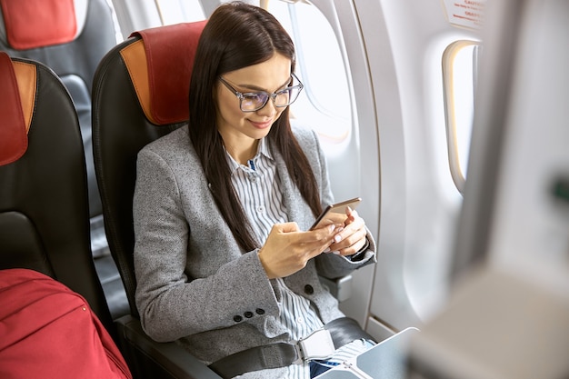 Bonne passagère caucasienne dans le salon de l'avion avant de voler