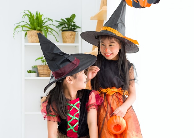 Bonne petite fille asiatique en costume de sorcière sur la fête de Halloween.