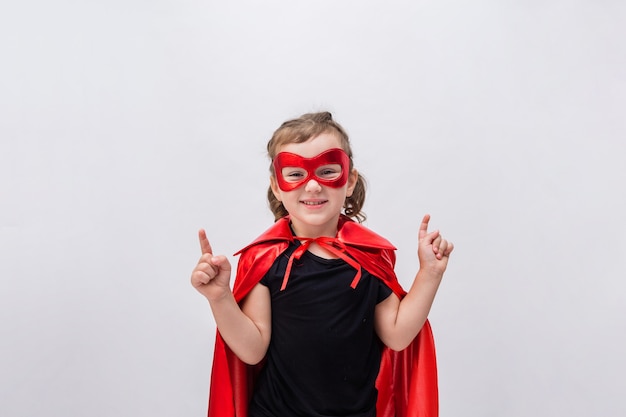 Bonne petite fille en costume de super-héros montrant ses mains