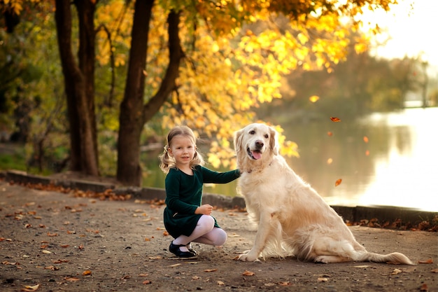 Bonne petite fille dans le parc en automne avec un chien