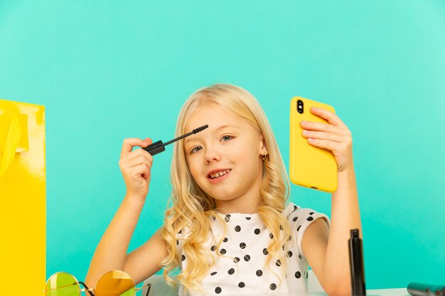 Bonne petite fille devant la caméra du téléphone faisant de la vidéo pour vlog.