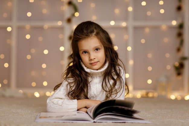 Bonne petite fille enfant lit un livre de contes de fées