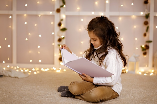 Bonne petite fille enfant lit un livre de contes de fées