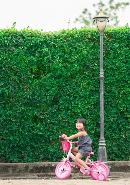 Bonne petite fille faire du vélo dans le parc