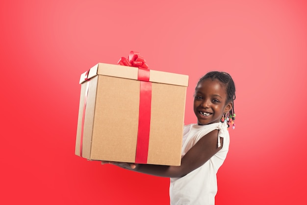 Bonne petite fille avec un gros cadeau de Noël