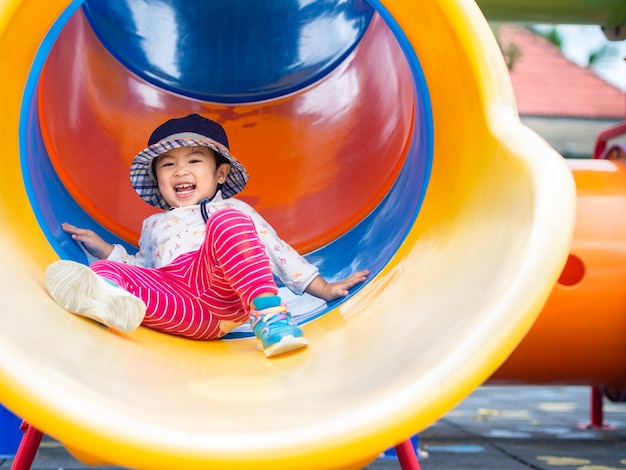 Bonne petite fille jouant au terrain de jeu. Enfants, Happy, Concept de famille.