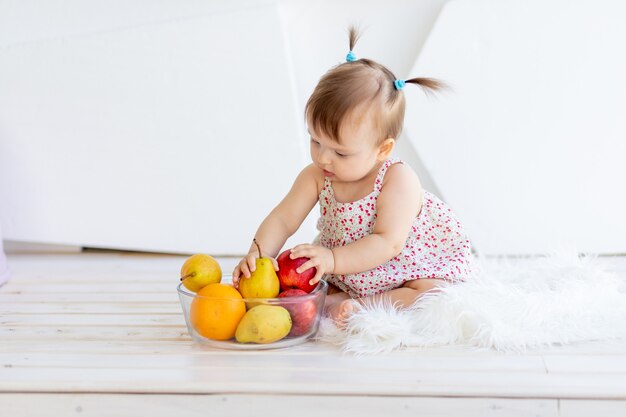 Bonne petite fille jouant avec des fruits