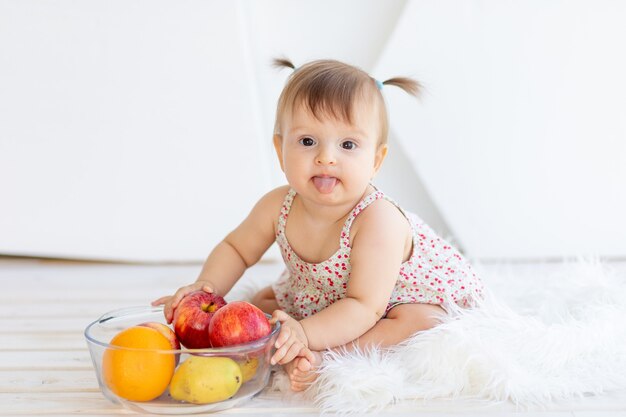 Bonne petite fille jouant avec des fruits