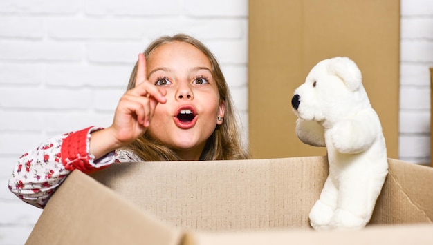 Bonne petite fille avec jouet achat d'une nouvelle habitation Boîtes en carton déménagement dans une nouvelle maison enfant heureux boîte en carton réparation de chambre nouvel appartement Dédié aux résultats