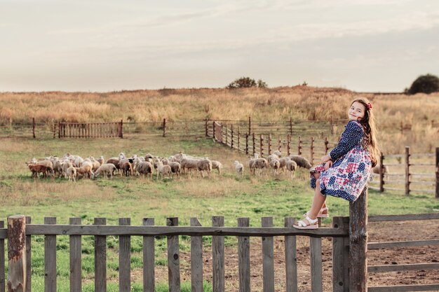 Bonne petite fille avec des moutons à la ferme