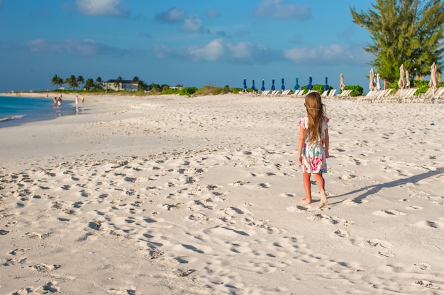 Bonne petite fille sur la plage pendant les vacances d'été