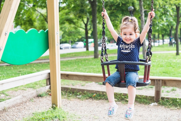 Photo bonne petite fille profitant de la balançoire