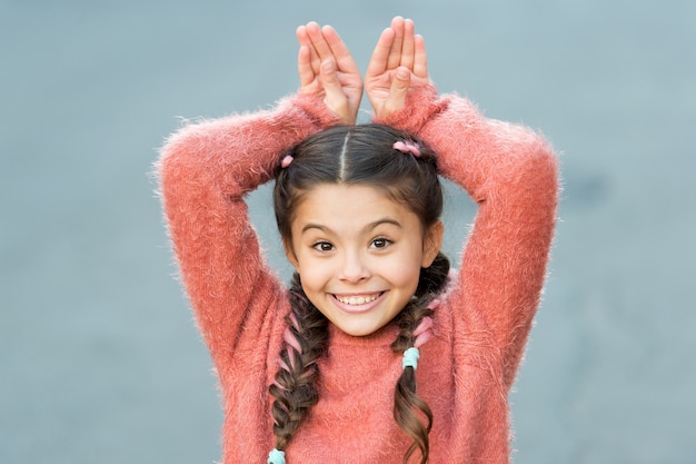 Bonne petite fille en pull d'automne. Petit enfant aux cheveux longs. D'une beauté décontractée. Enfance heureuse. Les câlins d'automne. Mode d'automne pour jolie fille. Pas de soucis. devenir fou. S'amuser.