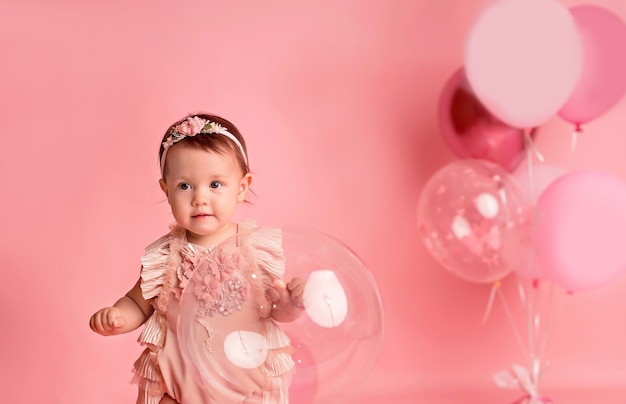 Bonne petite fille rose avec des ballons