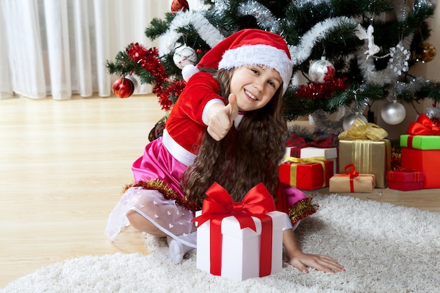 Bonne petite fille avec ses cadeaux de Noël