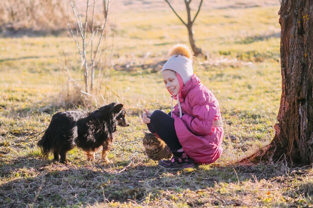 Bonne petite fille avec son chien dans un jardin rural