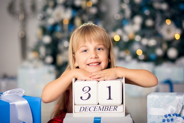 Bonne petite fille souriante avec boîte de cadeau de Noël.