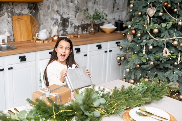 Bonne petite fille souriante avec boîte de cadeau de Noël.