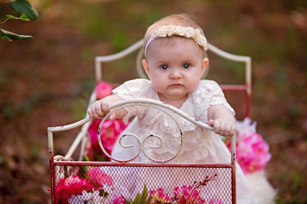 Bonne petite princesse bébé fille au lit avec des fleurs roses