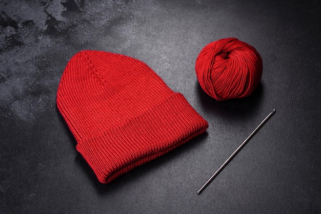 Bonnet de femme tricoté rouge chaud sur fond de béton Passe-temps et loisirs