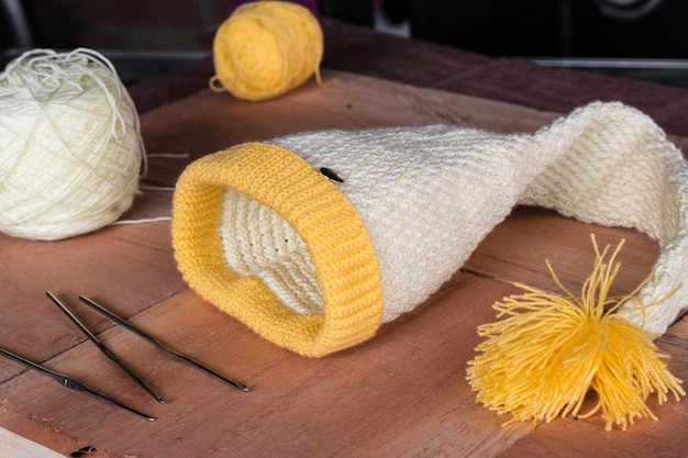 Bonnet d'hiver tricoté au crochet blanc et jaune avec des matériaux à concevoir et à tricoter à la maison