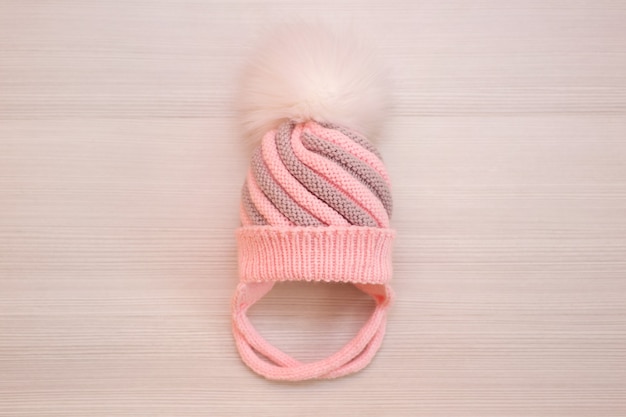 Bonnet en laine tricoté pour enfant rose à pompon, sur fond blanc