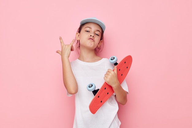 Bonnet de petite fille en tshirt blanc skateboard fond isolé