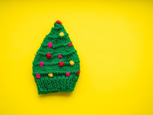 Bonnet vert en forme d'arbre de Noël sur fond jaune