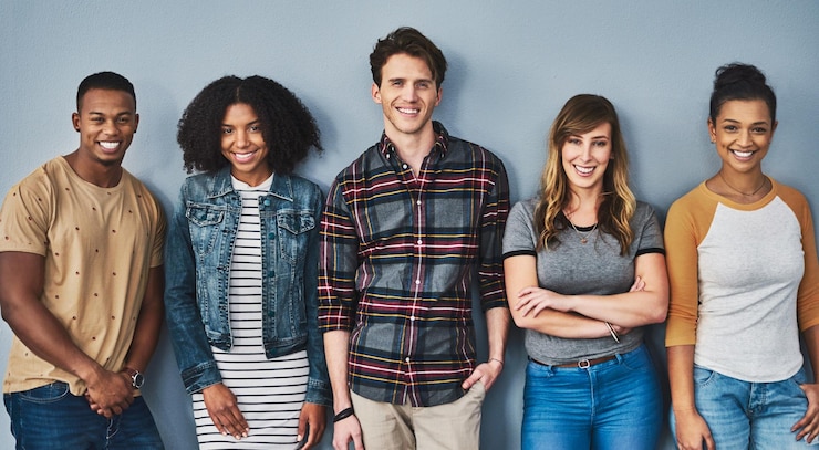 Photo de bons amis se tiennent ensemble studio portrait d'un groupe diversifié de jeunes debout ensemble sur un fond gris