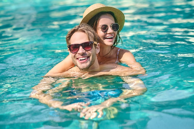 Bons moments. Jeune couple heureux, passer du temps dans une piscine