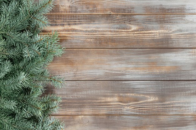 Bordure de Noël avec des branches de sapin sur un fond en bois.