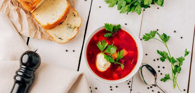 Bortsch avec du pain frais sur un fond en bois naturel. Soupe de betteraves rouges avec du pain frais