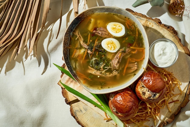 Bortsch vert avec du poulet dans une assiette sur une nappe blanche Cuisine ukrainienne