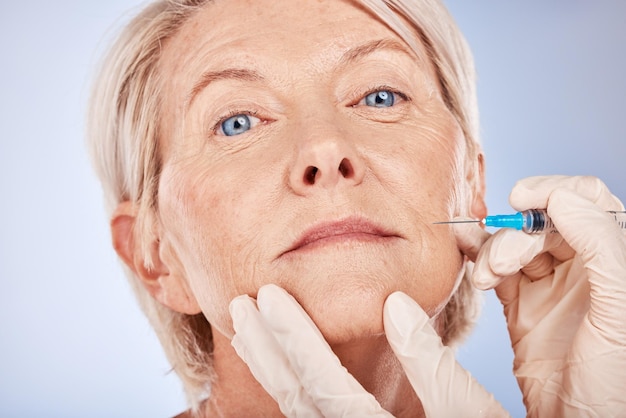 Botox femme âgée et injection pour la santé peau lisse et bien-être avec fond de studio gris Chirurgie plastique femme mature ou dame âgée avec aiguille fine soins du corps désintoxication du visage ou soins de la peau