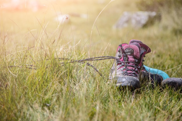 Les bottes alpines sont allongées dans l'herbe lors d'une randonnée