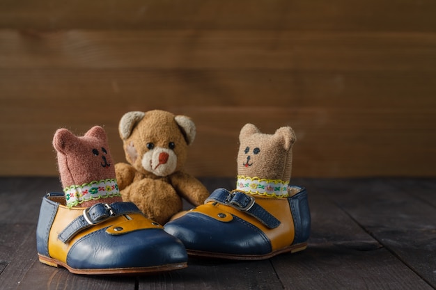 Bottes bébé et poupée jouet sur table en bois