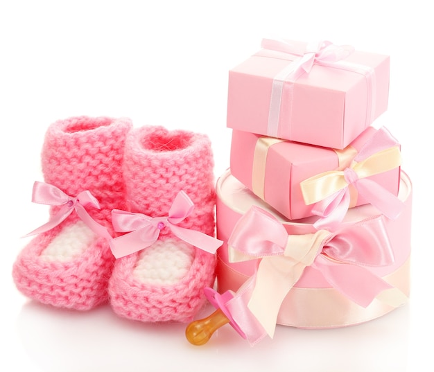 Bottes bébé rose, sucette et cadeaux isolés sur blanc