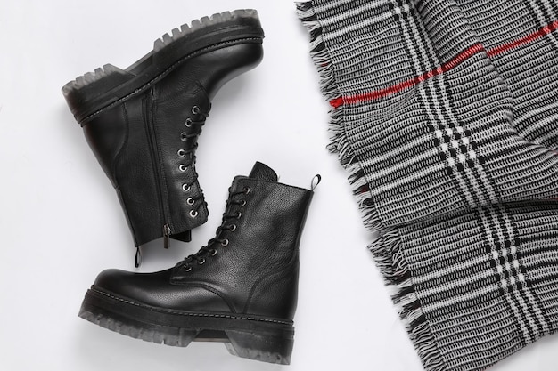 Bottes en cuir noir et écharpe sur fond blanc Vue de dessus Mise à plat