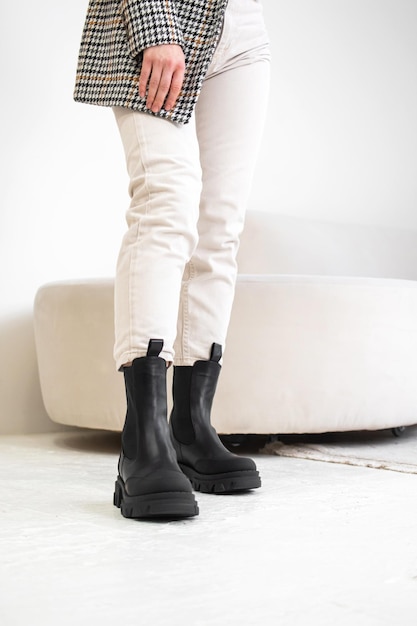 Bottes d'hiver confortables pour femmes. Style décontracté pour tous les jours. Prise de vue en studio. Fille de mode en pantalon blanc et veste photo