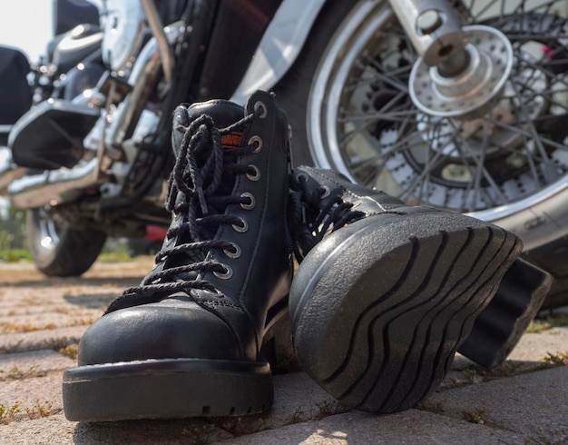 Bottes de motard avec lacets libre debout près de la roue d'un broyeur de moto