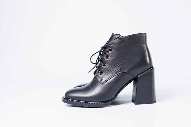 Bottes pour femmes en cuir véritable noir sur talons isolés sur fond blanc. photo de côté, en diagonale et en raccourci par derrière. Collection chaussures femme 2022