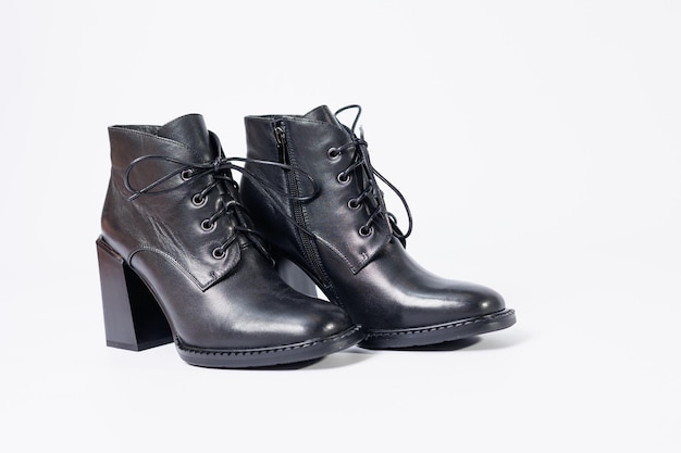 Bottes pour femmes en cuir véritable noir sur talons isolés sur fond blanc. photo de côté, en diagonale et en raccourci par derrière. Collection chaussures femme 2022