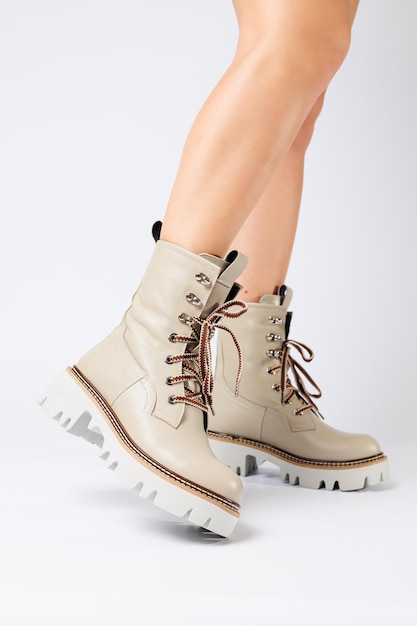 Les bottes de printemps blanches pour femmes en cuir véritable se portent sur la jambe d'une femme Nouvelle collection de bottes pour femmes 2022