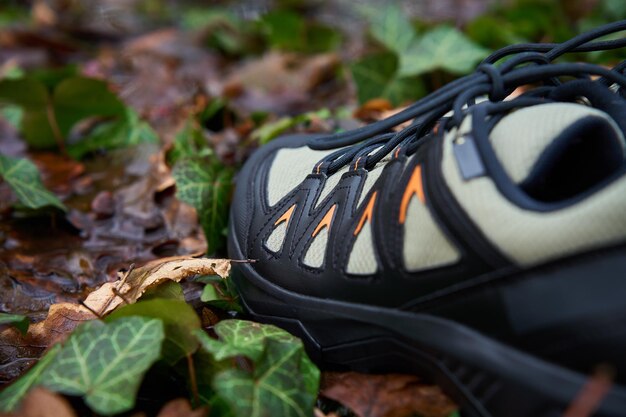 Des bottes de randonnée robustes dans une flaque sur le sentier forestier