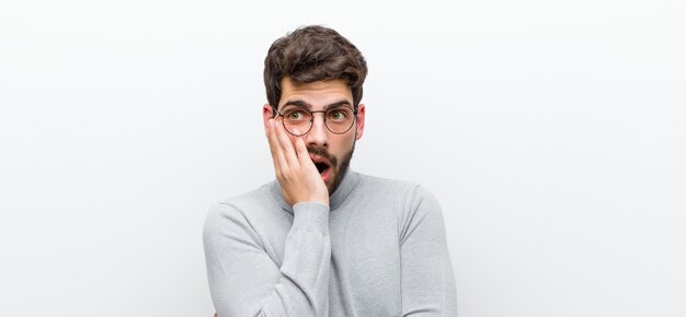 bouche bée sous le choc et l'incrédulité, la main sur la joue et le bras croisés, se sentant stupéfait et stupéfait