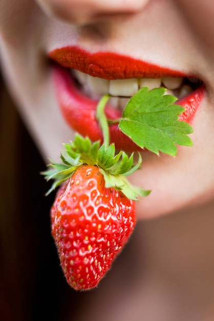 Bouche de femme avec fraise rouge