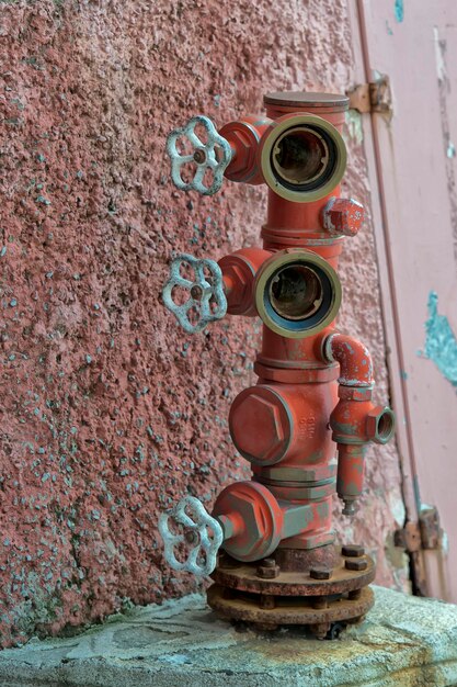 Photo bouche d'incendie près du mur rouge